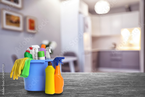 Fotomural Bucket with cleaning supplies on stone surface in modern room