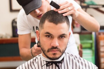 Canvas Print - Closeup shot of a young male getting a new stylish haircut in the barbershop