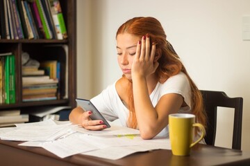 Sticker - Closeup shot of a young female looking at her phone instead of studying