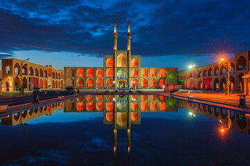 Wall Mural - Amir Chaqmaq complex facade illuminated at sunrise and reflecting in a pond, Yzad, Yazd province, Iran