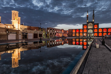 Wall Mural - Amir Chaqmaq complex facade illuminated at sunrise and reflecting in a pond, Yzad, Yazd province, Iran