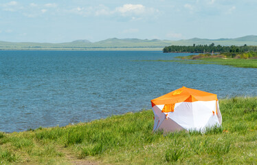 Tourist tent set up on the shore of a beautiful lake. travel and outdoor recreation.