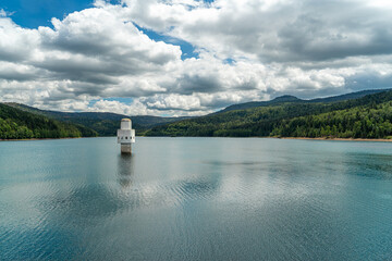 Stausee im Sommer mit einem Service-Turm in Wasser