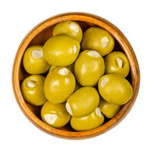 Green Olives Stuffed With Garlic Cloves In Wooden Bowl. Big Olives, Fruits Of Olea Europaea, Hand Filled With Pickled Garlic Pieces. Closeup From Above, On White Background, Isolated Macro Food Photo.