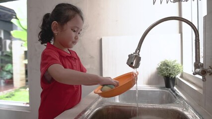 Wall Mural - kid washing the dishes. helpful young girl doing clean up at home