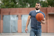 © Vladimir - Man with headphones stands on the street with a basketball in his hands