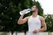© Vladimir - Sporty young man drinking water in park