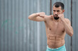 © Vladimir - Athlete conducts a fight with the shadow. A boxer trains punches on the street