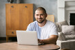 © muse studio - a handsome man with a beard at a laptop, communicating with loved ones
