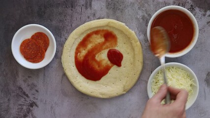 Wall Mural - Adding Tomato Sauce to a Pizza