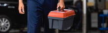 Horizontal Image Of Mechanic In Uniform Holding Toolbox In Service Station
