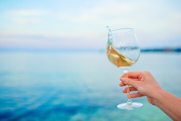 Wall Mural - Glass of white wine on tropical beach