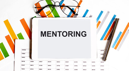 Poster - The tablet with text MENTORING on business charts and pen