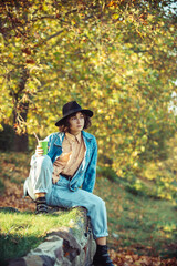 Wall Mural - Enjoying. Autumn model. Bright make up. Woman on background fall landscape leaves of trees.