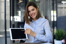 Young Happy Business Woman Showing Blank Tablet Computer Screen In Office.