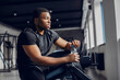 © prostooleh - Sports man in the gym. A black man performs exercises. Guy in a black t-shirt