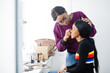 © AS Photo Family - African American woman applying make-up by make-up artist at beauty saloon.