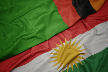 waving colorful flag of kurdistan and national flag of zambia.