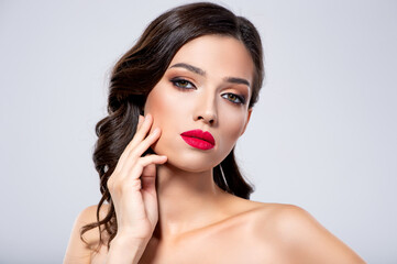 Wall Mural - Beautiful young fashion woman with red lipstick.  Brunette woman with a clean skin of face. Portrait of model with bright red lips. Glamour fashion model with bright gloss make-up  posing at studio.