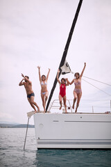 Wall Mural - Friends jumping from a yacht into the sea