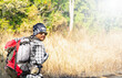 © nchamunee - Young man traveler with backpack hiking Lifestyle adventure concept, adventure active summer Forest, Hiking, Journey background.