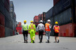 © Stella - The back of effectively managing staff worker team walking together at logistic shipping cargo containers yard