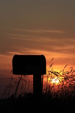 Kansas Country Mailbox Silhouette With Wheat And  A Colorful Sky And Sun.