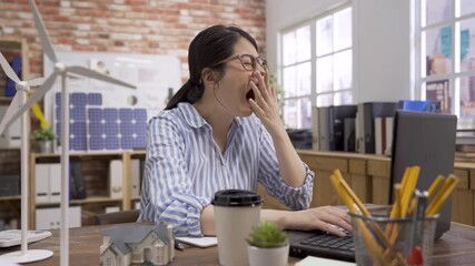 Wall Mural - tired businesswoman snoozing and yawning at workplace. Bored sleepy asian chinese female architect sitting half asleep at desk. lazy woman engineer disinterested in boring routine on laptop computer