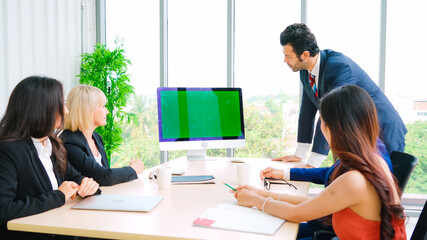 Wall Mural - Business people in the conference room with green screen chroma key TV or computer on the office table. Diverse group of businessman and businesswoman in meeting on video conference call .