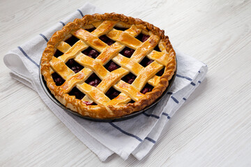 Wall Mural - Yummy Homemade Cherry Pie on a white wooden table, side view. Space for text.
