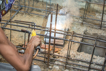 Worker welding steel structure at construction site