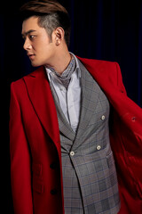 Asian fashionable man in red suit in black background