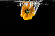 Yellow Pepper In Water Splash On Black Background
