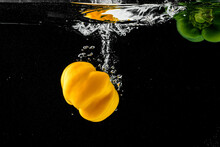 Yellow Pepper Splashing Into Water Splash On Black Background