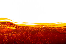 Blurred Background In Soft Focus With The Top Line Of Cola In A Glass And Bubbles. Concept - Summer Refreshing Drink With Sunbeams