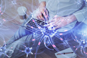 Neuron hologram with man working on computer on background. Education concept. Double exposure.