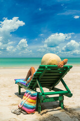 Wall Mural - Woman on a sun lounger at the white sand tropical beach