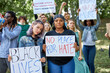 © Roman - black and white women leading a group of demonstrators in the park. Group of people protesting for human rights and against racism