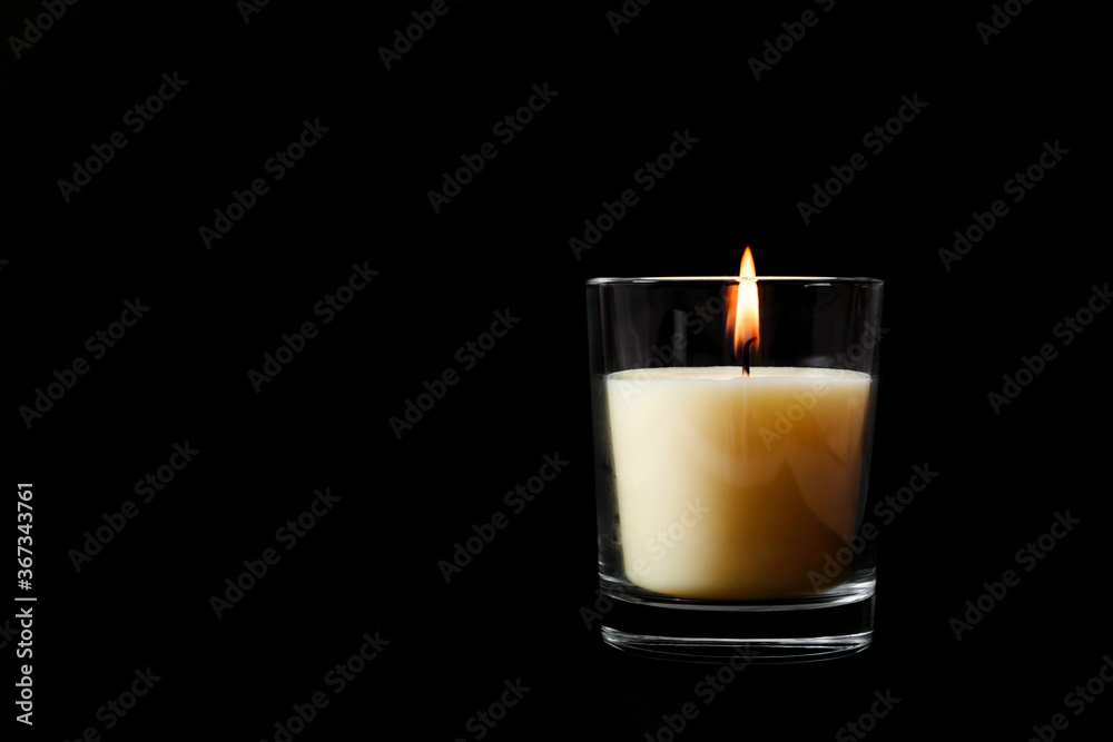 White wax burning candle in glass Isolated on black background, mock up - obrazy, fototapety, plakaty 