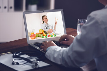 Wall Mural - Doctor using laptop for online consultation with nutritionist via video chat, closeup