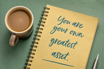 You are your own greatest asset inspirational note - handwriting in a spiral sketchbook with a cup of coffee, business, education and personal development concept