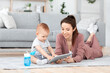 © Prostock-studio - Young Mom And Her Baby Son Playing Delevelopment Games On Digital Tablet