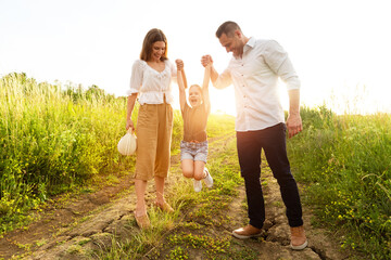 Wall Mural - Happy parents and kid walking together in summer