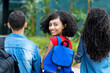 © Daniel Ernst - Laughing hispanic female student with backpack and group of friends