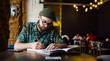 © mykolastock - Bearded oldschool young handsome romantic writer writing poem in notebook