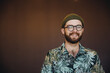 © mykolastock - Portrait of happy hipster male with beard wearing hat and eyeglasses looking at camera and smiling