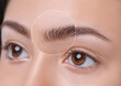 Eyebrows of a young teenager girl after plucking and cutting close-up. The make-up artist will do permanent eyebrow makeup. Makeup and cosmetology concept, eyebrow shape modeling.