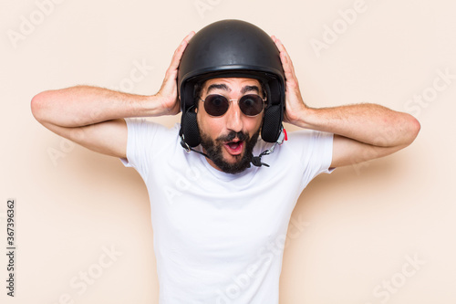 Fotomural young cool bearded man surprised with a helmet. motorbike rider
