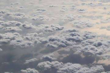 Wall Mural - white clouds over the blue ocean, view from the plane window