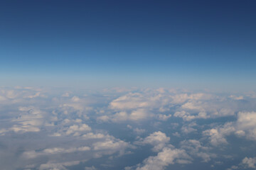 Wall Mural - beautiful white clouds on blue sky, view from airplane window